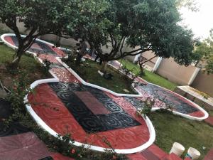 AtasomansoKiverly Guest House的花园内有红黑地毯和树木