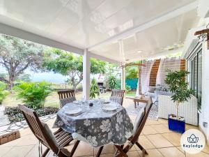 圣保罗F4 - Villa Cadentia - 120 m² - piscine - Saint-Gilles-les-Hauts的庭院内带桌椅的用餐室