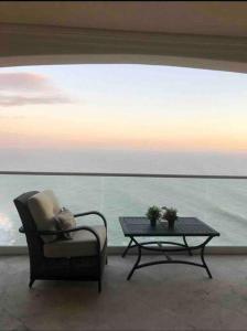 罗萨里托Ocean Front Condo @ Las Olas Grand的水前的椅子和茶几