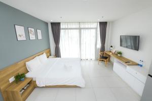 土龙木市LP rental - Minimalist Studio Apartments的卧室配有白色的床和电视。