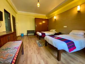 加德满都Hotel Siddhi Manakamana的酒店客房带两张床和长凳