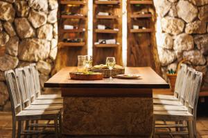 下米拉诺瓦茨Zeleni zaliv-The Green Bay的一张桌子、两把椅子和酒杯