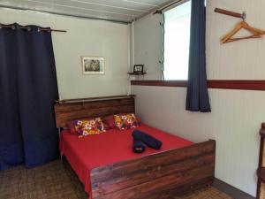 努库希瓦Noho Mai的一间卧室设有红色的床和窗户。