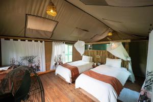 NataNata Lodge的一间帐篷内带两张床的卧室