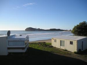 卡斯尔波因特Castlepoint Holiday Park & Motels的沙滩上的露营车和拖车