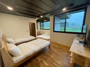 水里乡奕青民宿-梅酒 梅精 法國麵包plum winery guesthouse的客房设有两张床和大窗户。