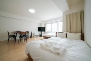 札幌Residence Hotel KABUTO的一间卧室配有一张带两条白色毛巾的床
