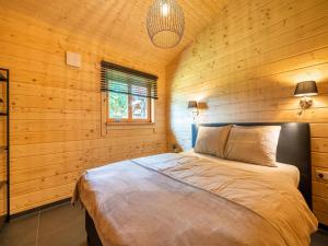 SchinnenCozy holiday home in Limburg with a beautiful view的卧室配有木墙内的一张床