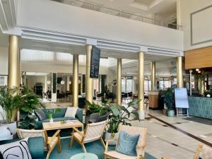 乌普萨拉维多利亚酒店与会议中心的大堂配有沙发、桌子和植物
