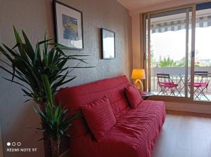 蒙特里夏尔Appartement 2 P 5 PER ENTRE BEAUVAL & CHENONCEAU的带阳台的客厅内的红色沙发