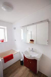 吕贝克Wohnen am Park的白色的浴室设有水槽和浴缸。
