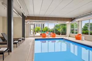 罗林梅多斯绍姆堡-罗林梅多斯假日酒店的橙色装饰的酒店客房内的游泳池
