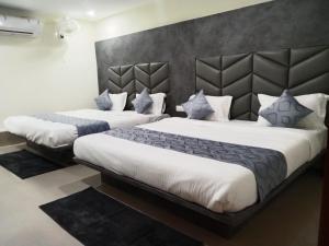 巴罗达HOTEL RK VILLA的白色和蓝色的酒店客房内的两张床