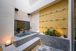东京Hotel P'sResort Adults only 大人専用的带浴缸和电视的大浴室。