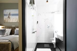 维也纳Hotel Resonanz Vienna的带淋浴、床和盥洗盆的浴室