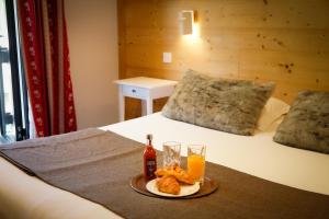 Villar-dʼArène法拉池酒店的一张床上放着食物和饮料的托盘