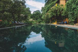 宁平Trang An Ecolodge的水面上映着天空的游泳池