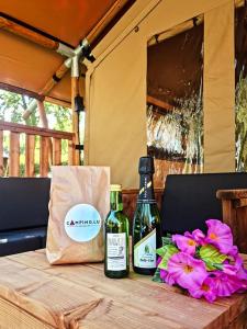 贝尔多夫Safari Tent M的两瓶葡萄酒坐在带鲜花的桌子上