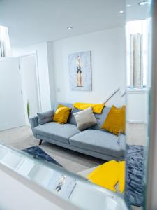 哈德斯菲尔德Stylish Spacious 1 Bedroom Apt At Dealhouse的客厅配有蓝色沙发及黄色枕头