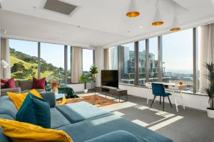 开普敦117 on Strand Luxury Apartments的客厅设有蓝色的沙发和大窗户