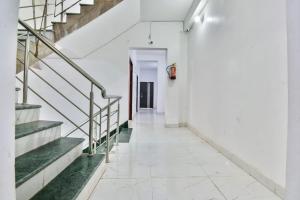 GulzārbāghOYO Flagship Rainbow Homestay的白色建筑的走廊,有楼梯