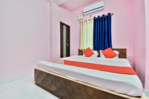 GulzārbāghOYO Flagship Rainbow Homestay的一间卧室配有一张带红色和蓝色枕头的大床