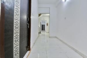 GulzārbāghOYO Flagship Rainbow Homestay的一条空的走廊,有门,铺着瓷砖地板