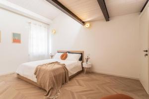 里米尼Luxury & Design: Oasi nel centro storico di Rimini的一间铺有木地板的白色卧室,配有一张床