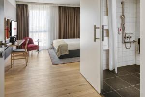 海德堡IntercityHotel Heidelberg的配有一张床和一张书桌的酒店客房