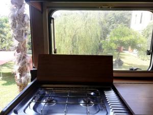 CordenonsIl Camper di Ermione的一间带炉灶的厨房 窗边的顶部烤箱