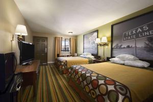 柴尔德里斯Super 8 by Wyndham Childress的酒店客房设有两张床和一台平面电视。