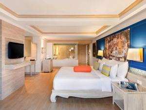 芭东海滩Novotel Phuket Resort的酒店客房设有一张大床和一台电视。