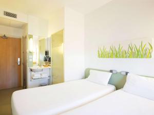 塞维利亚塞维利亚机场宜必思快捷酒店 的带浴室的客房内的2张白色床