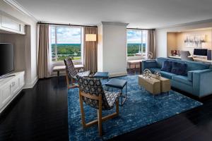 威奇托威奇塔君悦酒店的一间带蓝色沙发的客厅和一间带电视的客厅。