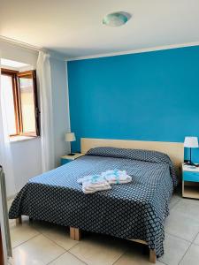 瓦洛-德拉卢卡尼亚La Casa al Piccolo Borgo的蓝色卧室,配有带毛巾的床