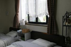 神户Private Inn Bambee的一间卧室设有两张床和窗户。