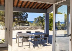 拉科纳B&B Villa Costanza的庭院内带桌椅的用餐室