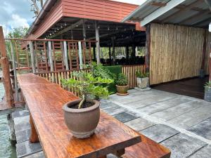 高兰Lanta Sabai Day House的天井上木桌,种植了盆栽植物