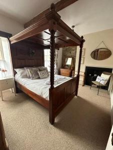 贝尔福德The Corner House Belford的一间卧室配有一张木天蓬床。