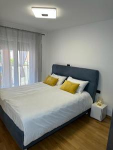 乌马格APPLeonLux的一间卧室配有一张带黄色枕头的大床
