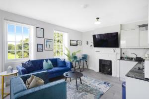 伦敦LiveStay - London Chiswick Apartments with Free Parking的客厅设有蓝色的沙发和壁炉