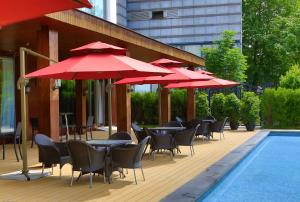 北京北京五洲大酒店的游泳池旁一排带红伞的桌椅