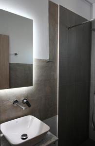 穆尔特里Costa Varda Apartments的浴室配有盥洗盆和带镜子的淋浴