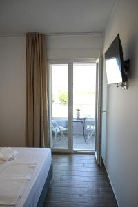 穆尔特里Costa Varda Apartments的一间卧室设有一张床,并有通往庭院的门