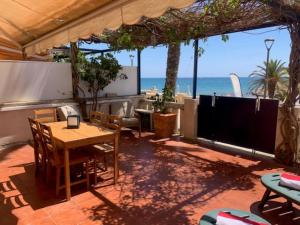 锡切斯AIGUADOLÇ APARTMENT的一个带桌椅的庭院和海滩