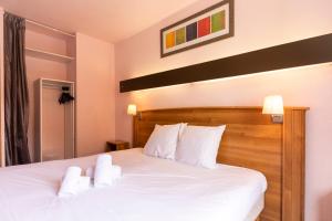 莱德萨阿尔卑斯HOTEL DES NEIGES的一间卧室配有带白色床单和枕头的床。
