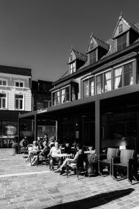 托尔豪特Hotel Brasserie De Beiaard的一群坐在大楼外桌子上的人