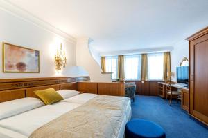 因斯布鲁克蒙德施恩酒店的配有一张床和一张书桌的酒店客房