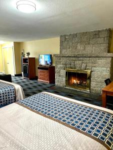 北康威瑞士小屋村旅馆的酒店客房设有壁炉和一张床。