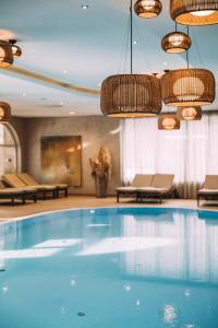 翁肯POST Family Resort的酒店客房的大型游泳池设有吊灯